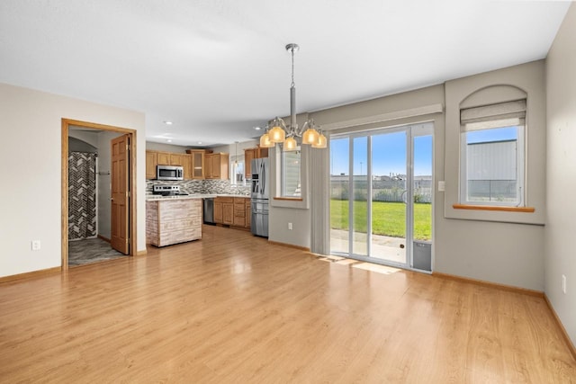 1949 24th St, Minot, ND 58701 - unfurnished living room with light wood finished floors and a chandelier