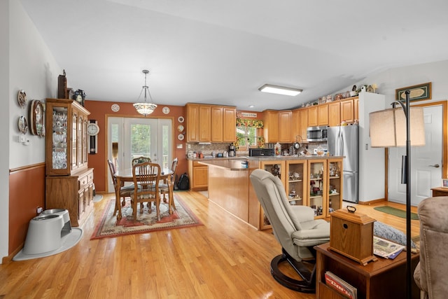 2710 66th St, Minot, ND 58703 - kitchen with appliances with stainless steel finishes, light wood-style flooring, tasteful backsplash, light countertops, and lofted ceiling