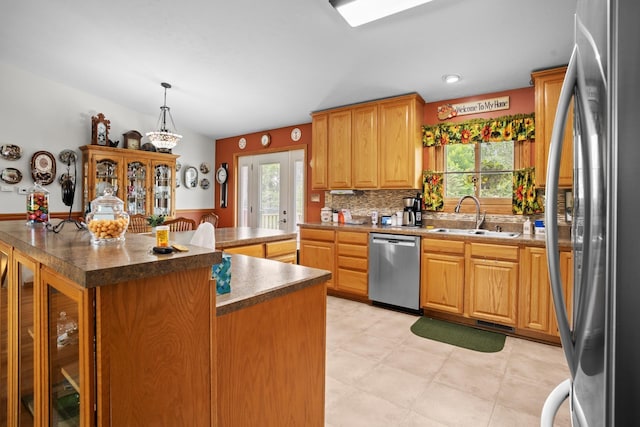2710 66th St, Minot, ND 58703 - kitchen featuring appliances with stainless steel finishes, plenty of natural light, a center island, decorative backsplash, and a wainscoted wall