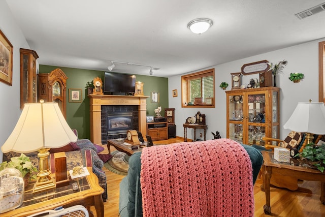 2710 66th St, Minot, ND 58703 - bedroom featuring a tiled fireplace, wood finished floors, and rail lighting