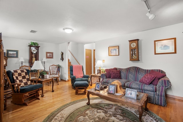 2710 66th St, Minot, ND 58703 - living area featuring wood finished floors, track lighting, and stairs