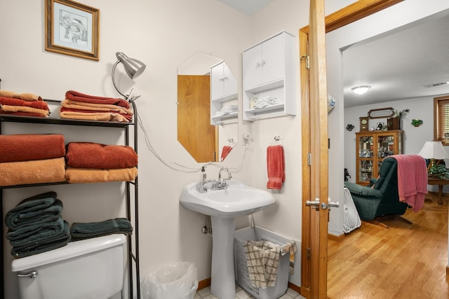 2710 66th St, Minot, ND 58703 - ensuite bathroom featuring toilet and wood finished floors