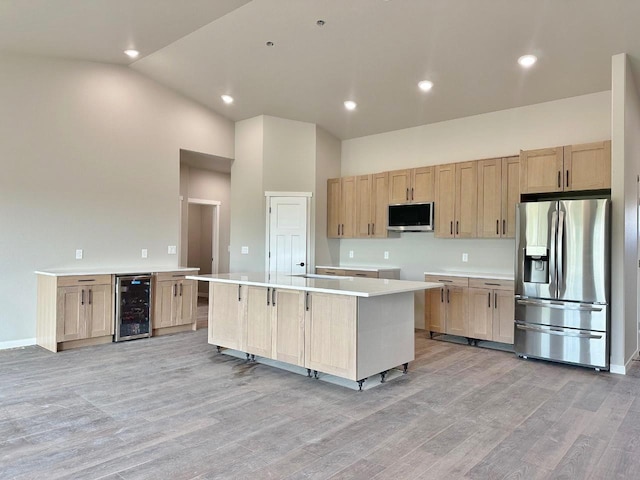 1609 Heights Ave, Burlington, ND 58722 - kitchen featuring stainless steel appliances, wine cooler, light brown cabinetry, light wood-style flooring, and high vaulted ceiling