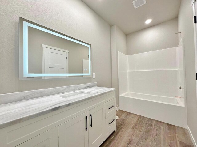 1609 Heights Ave, Burlington, ND 58722 - bathroom featuring wood finished floors, vanity, and shower / washtub combination