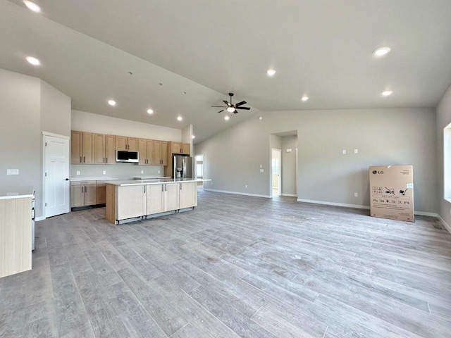 1609 Heights Ave, Burlington, ND 58722 - kitchen featuring stainless steel appliances, open floor plan, light countertops, a center island with sink, and lofted ceiling
