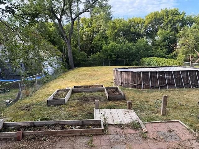 724 Burdick Expy, Minot, ND 58701 - view of green lawn featuring a garden and an outdoor pool