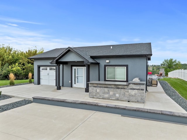 2009 35th Ave, Minot, ND 58701 - ranch-style house with stucco siding, an attached garage, a shingled roof, stone siding, and driveway