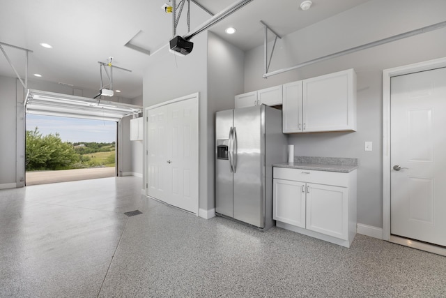 2009 35th Ave, Minot, ND 58701 - garage with stainless steel fridge, a garage door opener, and recessed lighting
