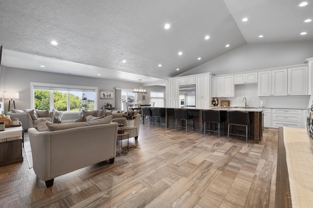 2009 35th Ave, Minot, ND 58701 - living area featuring a chandelier, high vaulted ceiling, and recessed lighting