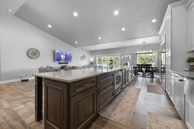 2009 35th Ave, Minot, ND 58701 - kitchen with light countertops, white cabinets, stainless steel microwave, dark brown cabinetry, and recessed lighting