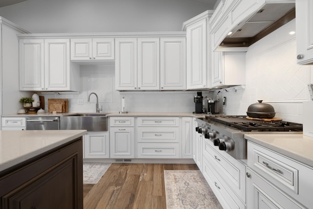 2009 35th Ave, Minot, ND 58701 - kitchen with range hood, stainless steel appliances, tasteful backsplash, light countertops, and white cabinets