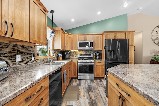 1808 28th St, Minot, ND 58703 - kitchen featuring black appliances, vaulted ceiling, dark wood finished floors, tasteful backsplash, and decorative light fixtures