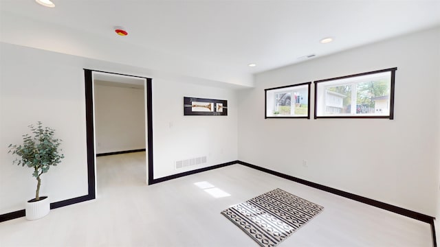 1113 10th St, Minot, ND 58703 - unfurnished bedroom with light wood-style floors, recessed lighting, and a spacious closet
