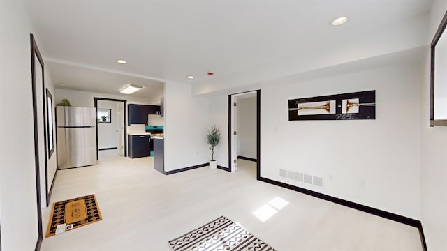 1113 10th St, Minot, ND 58703 - empty room featuring light wood-style flooring and recessed lighting