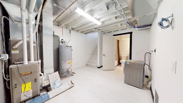1113 10th St, Minot, ND 58703 - unfinished basement featuring gas water heater, stairs, heating unit, and light wood finished floors