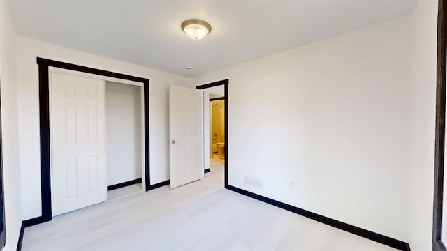 1113 10th St, Minot, ND 58703 - unfurnished bedroom with light wood finished floors and a closet