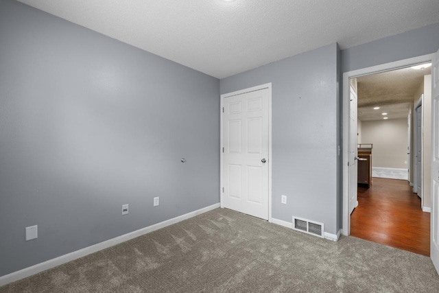 606 19th Ave Unit 7, Minot, ND 58701 - unfurnished bedroom featuring carpet and a textured ceiling