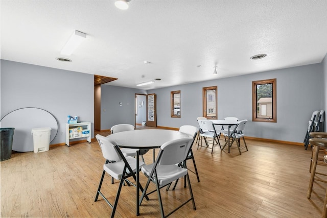 606 19th Ave Unit 7, Minot, ND 58701 - dining area with light wood-style floors and a textured ceiling