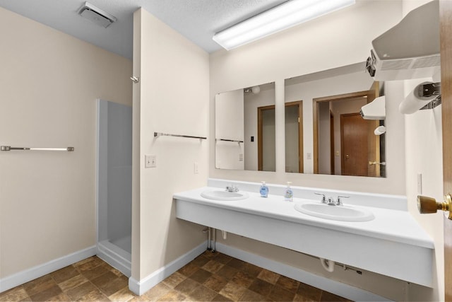 606 19th Ave Unit 7, Minot, ND 58701 - bathroom featuring double vanity, a stall shower, and stone finish flooring