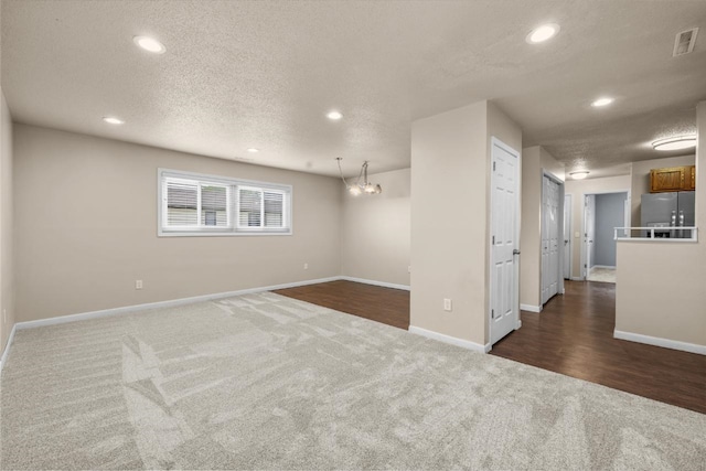 606 19th Ave Unit 7, Minot, ND 58701 - spare room with dark carpet, recessed lighting, a textured ceiling, and a chandelier