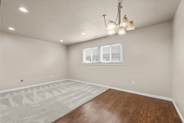 606 19th Ave Unit 7, Minot, ND 58701 - spare room with a textured ceiling, recessed lighting, a chandelier, and wood finished floors
