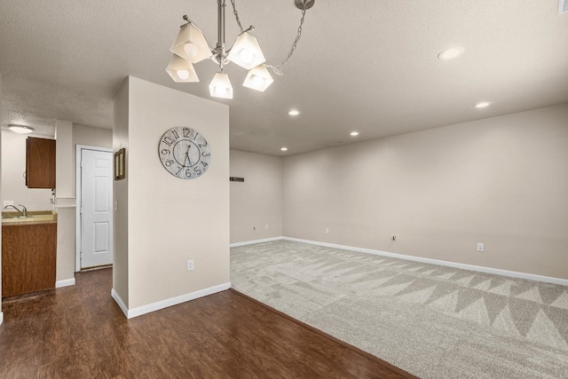 606 19th Ave Unit 7, Minot, ND 58701 - carpeted spare room featuring a chandelier, wood finished floors, recessed lighting, and a textured ceiling