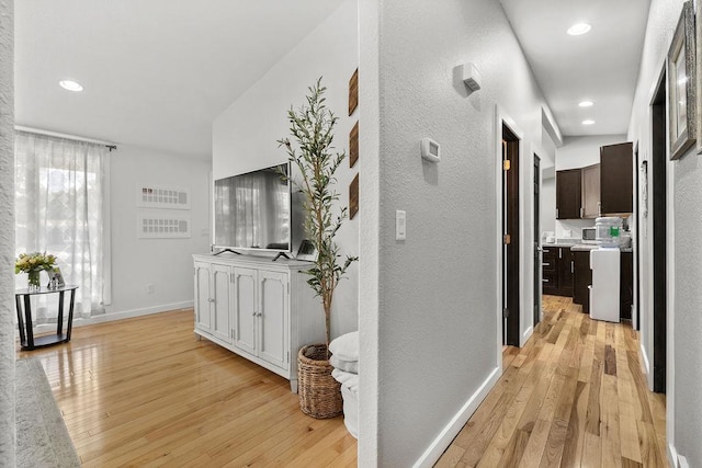 120 25th St, Minot, ND 58701 - corridor featuring light wood-style flooring, a textured wall, and recessed lighting