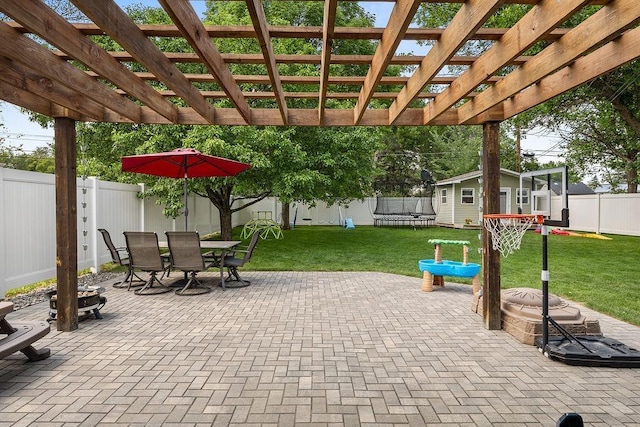 120 25th St, Minot, ND 58701 - fenced backyard featuring a trampoline, a patio area, outdoor dining area, an outbuilding, and a pergola
