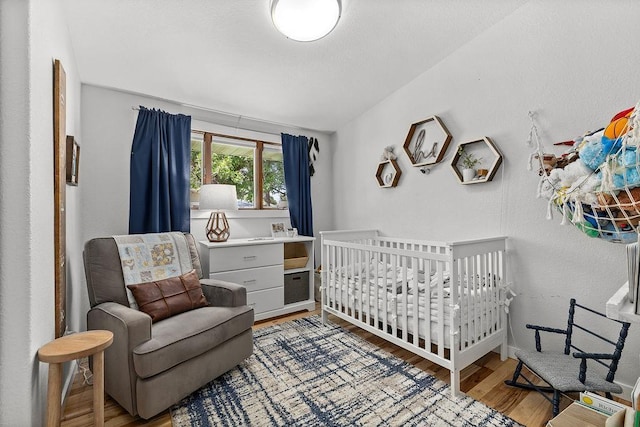120 25th St, Minot, ND 58701 - bedroom featuring light wood-type flooring and a crib