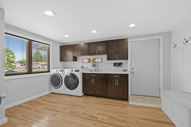 120 25th St, Minot, ND 58701 - laundry area with cabinet space, independent washer and dryer, light wood finished floors, and recessed lighting
