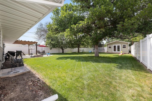120 25th St, Minot, ND 58701 - fenced backyard with french doors, an outdoor structure, a patio area, and a pergola