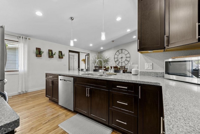 120 25th St, Minot, ND 58701 - kitchen featuring stainless steel appliances, dark brown cabinets, light wood-type flooring, a peninsula, and recessed lighting