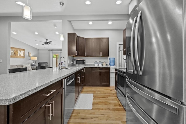 120 25th St, Minot, ND 58701 - kitchen with appliances with stainless steel finishes, a peninsula, light wood-style flooring, dark brown cabinetry, and recessed lighting