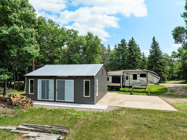 4706 SE 37th St, Minot, ND 58701 - rear view of house featuring a yard, an outdoor structure, and a metal roof