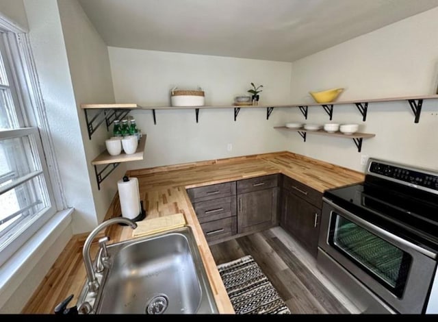 607 Main St, Minot, ND 58701 - kitchen with stainless steel range with electric stovetop, open shelves, butcher block counters, and dark wood-style floors