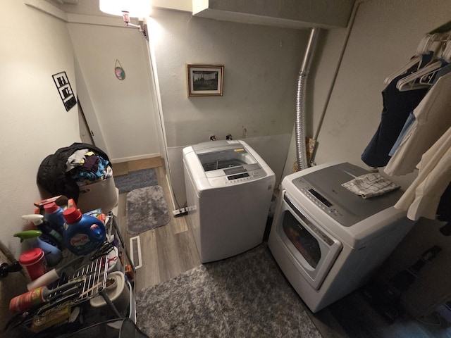 607 Main St, Minot, ND 58701 - washroom with washer and clothes dryer and wood finished floors