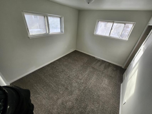 607 Main St, Minot, ND 58701 - empty room with dark carpet and baseboards