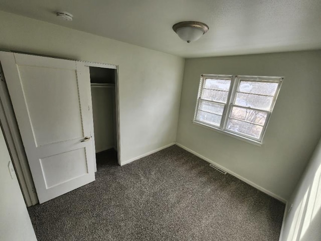 607 Main St, Minot, ND 58701 - unfurnished bedroom with dark colored carpet and a closet