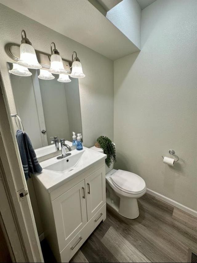 607 Main St, Minot, ND 58701 - half bath featuring vanity and wood finished floors