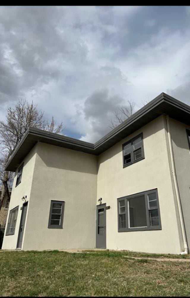 607 Main St, Minot, ND 58701 - back of property featuring stucco siding and a lawn