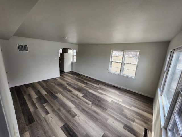 607 Main St, Minot, ND 58701 - unfurnished room with arched walkways and dark wood-style floors