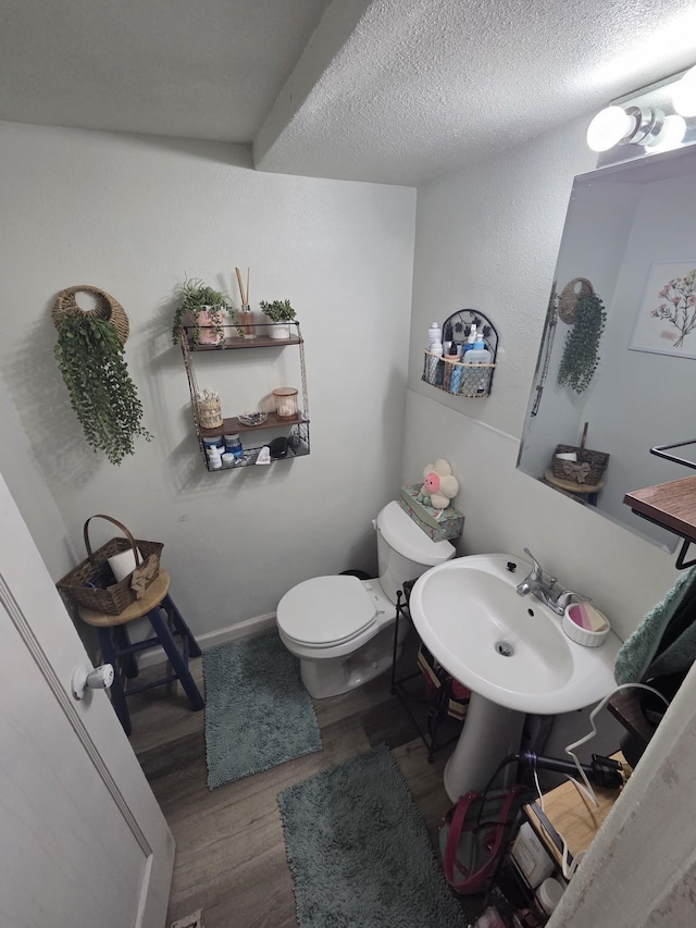 607 Main St, Minot, ND 58701 - half bathroom with wood finished floors and a textured ceiling