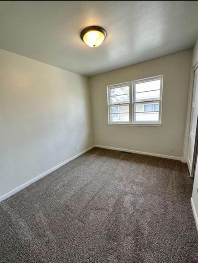 607 Main St, Minot, ND 58701 - unfurnished room featuring dark carpet