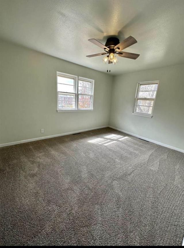 607 Main St, Minot, ND 58701 - carpeted empty room with ceiling fan and a textured ceiling
