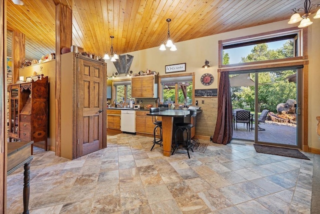 309 4th Ave, Mohall, ND 58761 - kitchen featuring dishwasher, stone tile flooring, dark countertops, wooden ceiling, and a breakfast bar