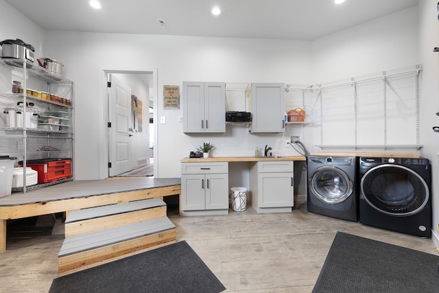 2415 43rd Ave, Minot, ND 58701 - laundry room with washer and clothes dryer, cabinet space, recessed lighting, and light wood finished floors