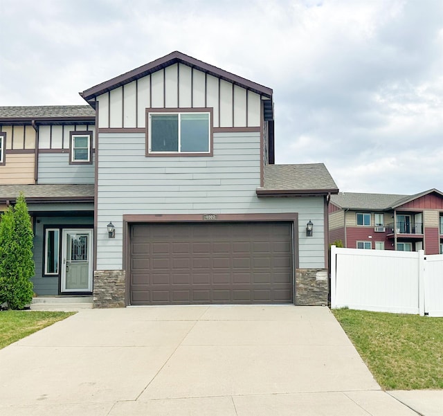 4007 Crossing St, Minot, ND 58701 - view of front of home with board and batten siding, stone siding, a garage, and concrete driveway