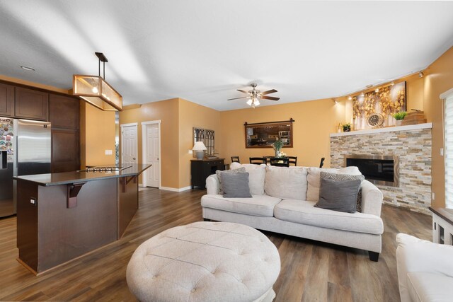 4007 Crossing St, Minot, ND 58701 - living room with a ceiling fan, dark wood-type flooring, and a stone fireplace