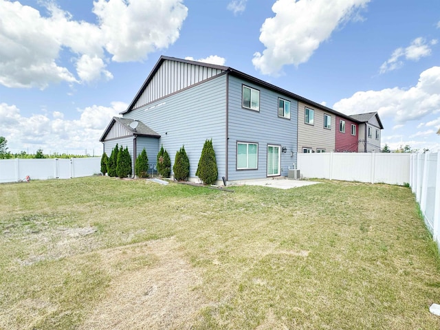 4007 Crossing St, Minot, ND 58701 - rear view of property featuring board and batten siding, a fenced backyard, and a patio