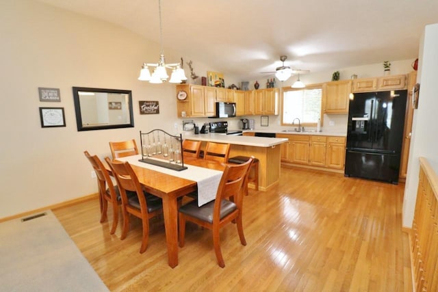 2033 14th St, Minot, ND 58703 - dining room with light wood-style flooring, a chandelier, ceiling fan, and lofted ceiling